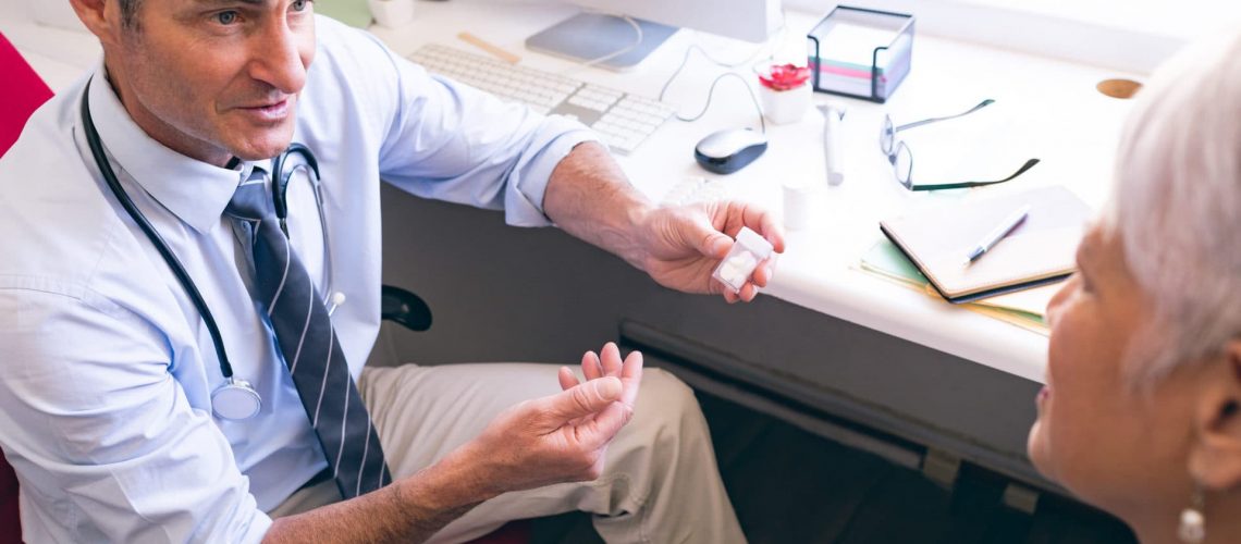 Male doctor prescribing medicine to senior woman